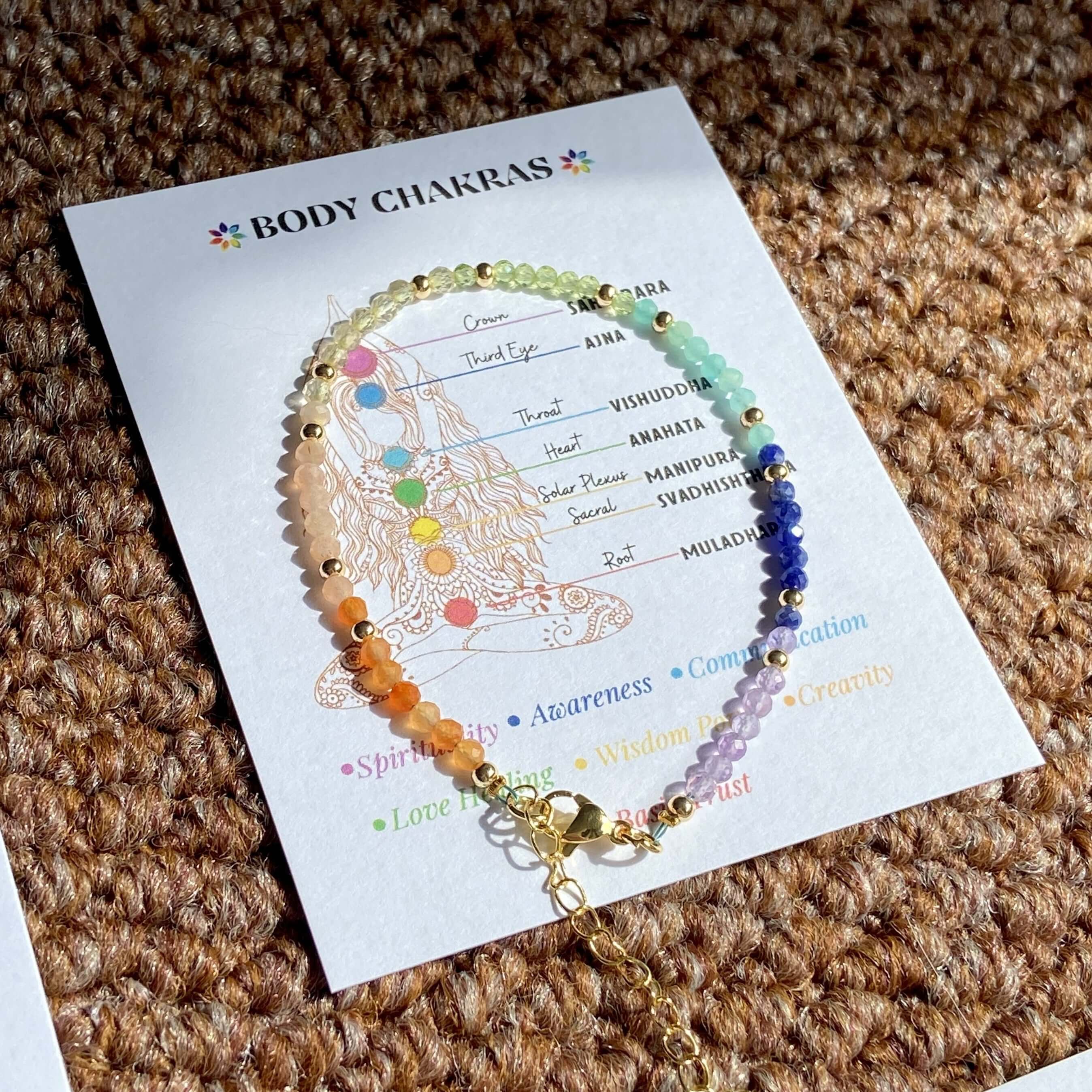 7 Chakra Crystal Bracelet with color-coded stones on a chakra guide card, enhancing energy flow and spiritual balance.