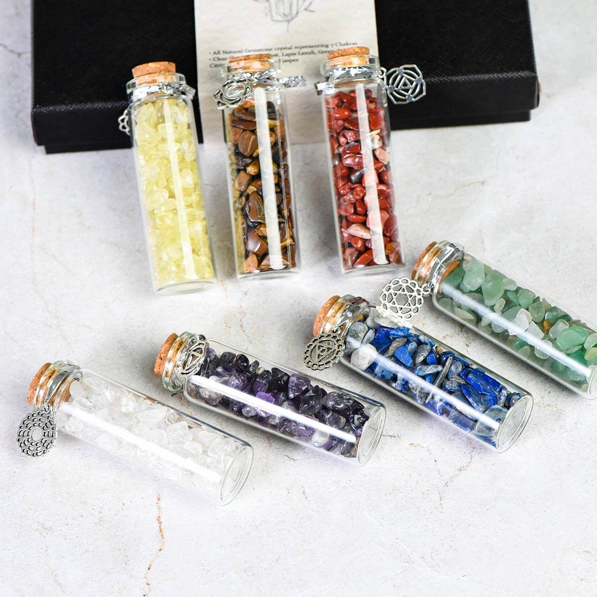 7 Chakra Wish Bottle Set with colorful crystals in glass bottles for spiritual healing and chakra alignment.