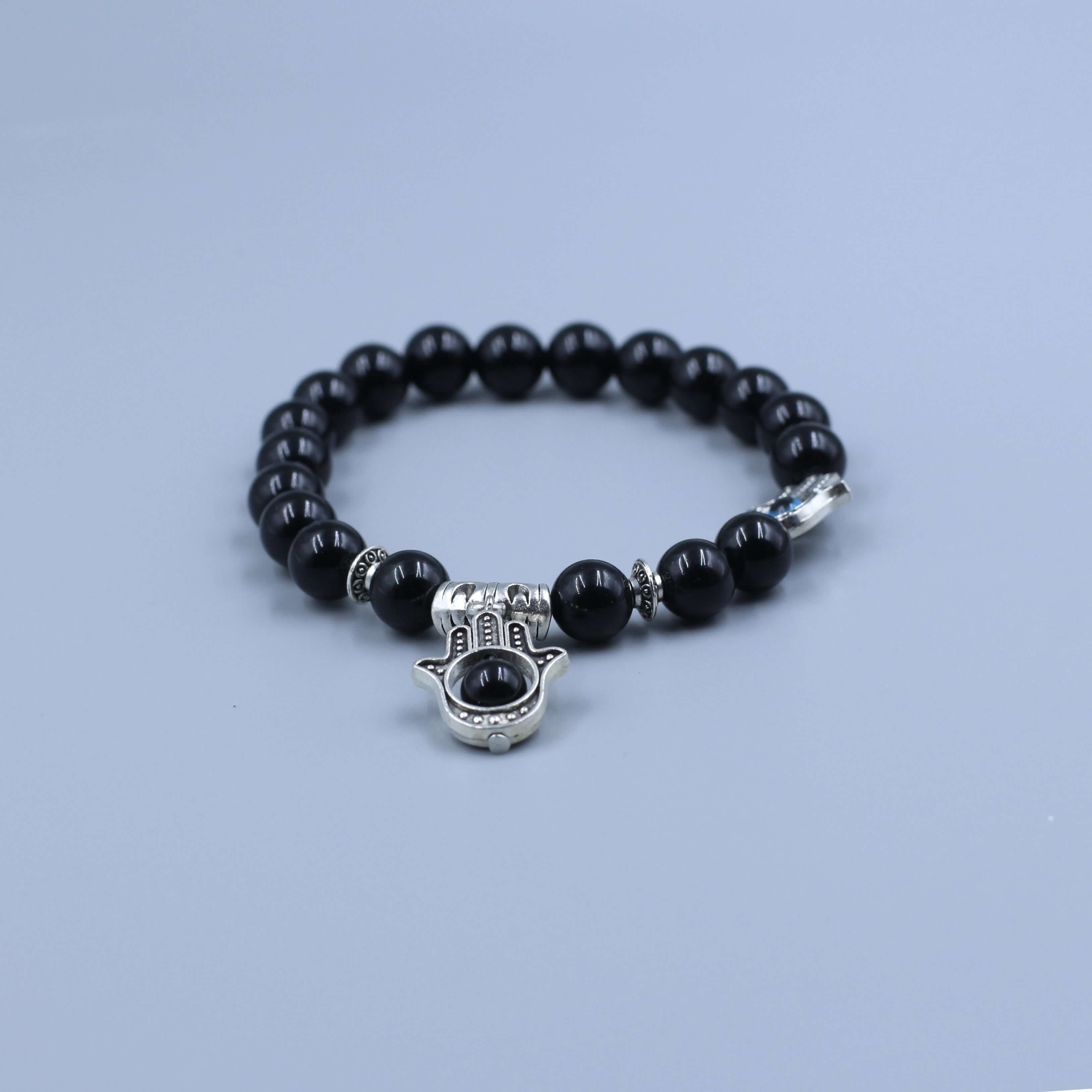 The Eye of Horus Bracelet-Health & Insight with black beads and silver Horus charm on a grey background