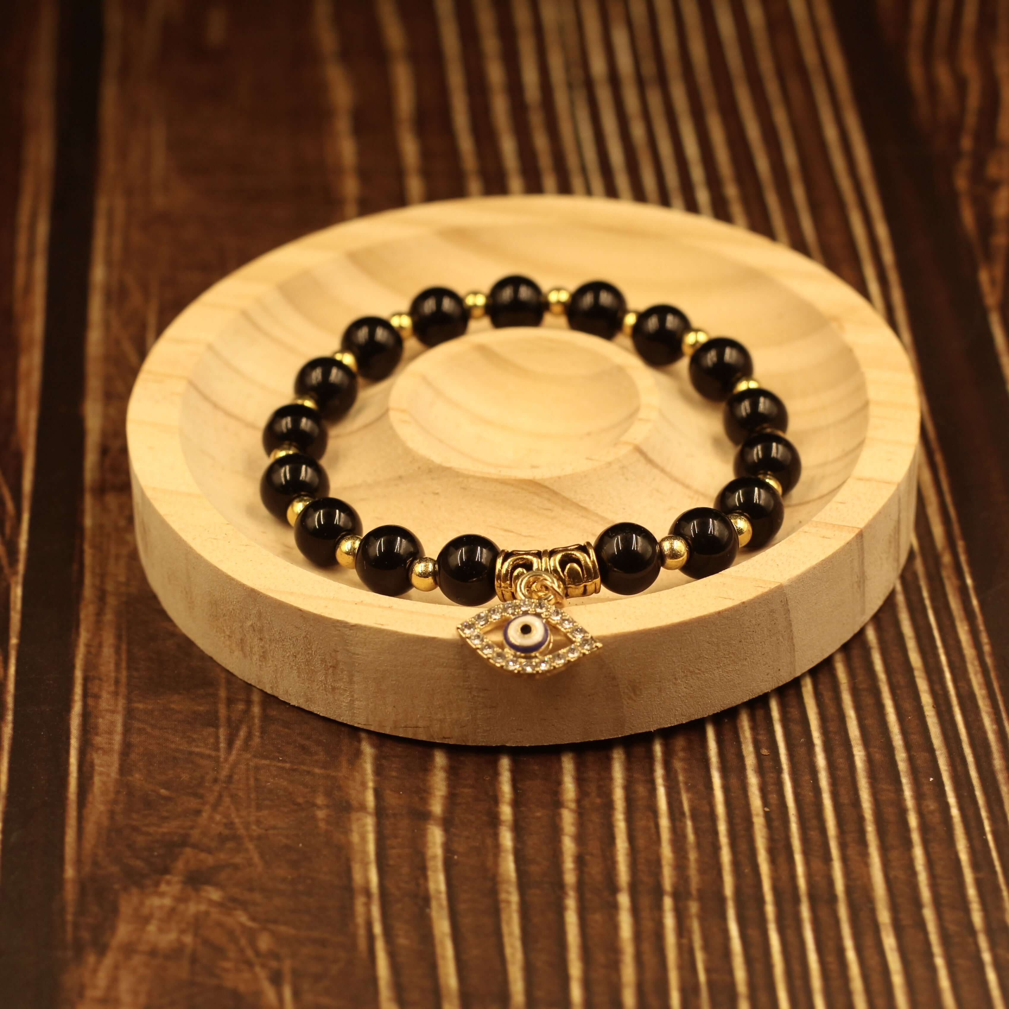 Evil Eye Bracelet-Protection with black beads and amulet on wooden display tray, wards off negativity and brings good fortune.