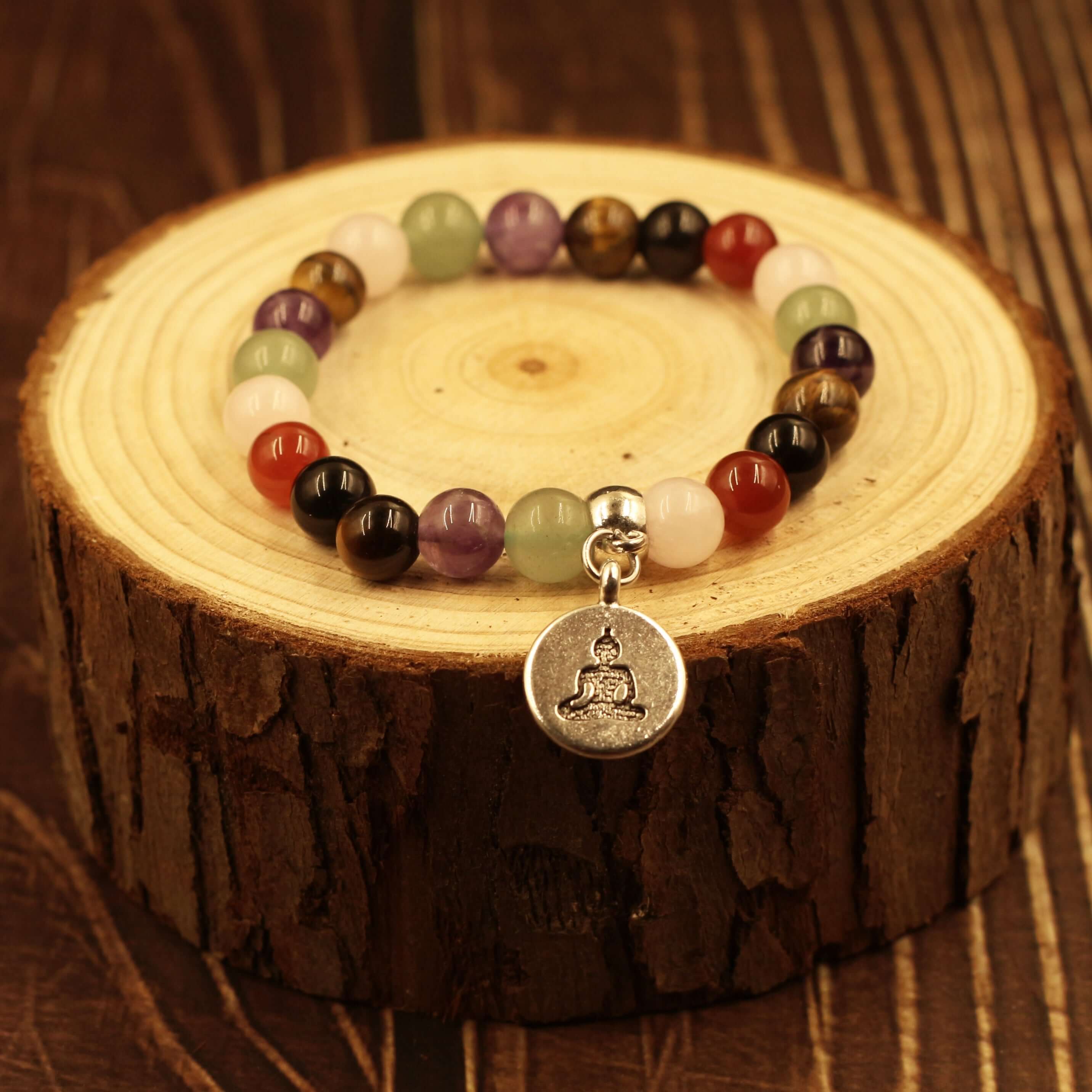 7 Chakra Healing Bracelet-Harmony & Balance on wooden background displaying natural gemstones and charm