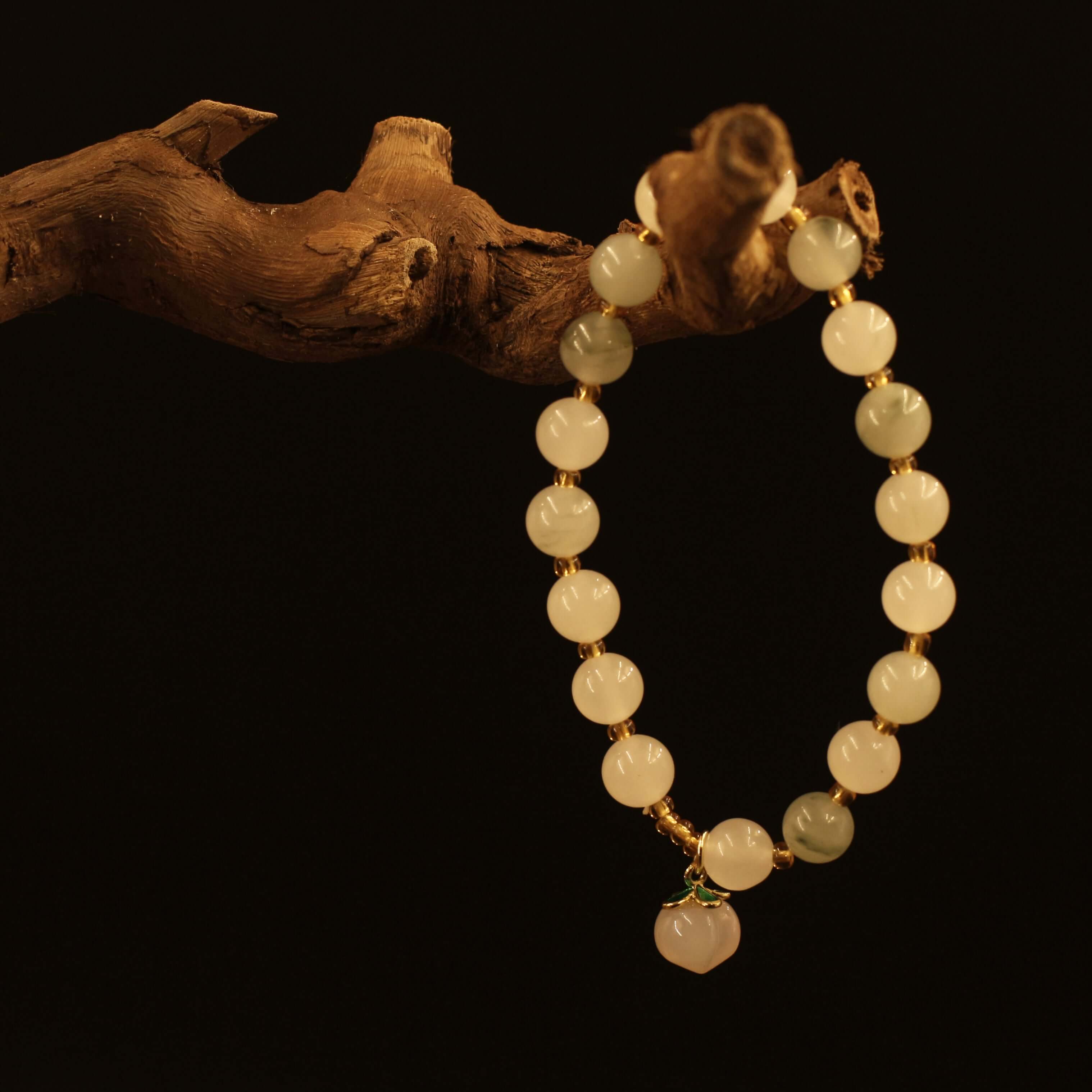 Yanyuan Agate Peach Bracelet hanging on a branch, symbolizing health and peace with unique textures and rich colors.