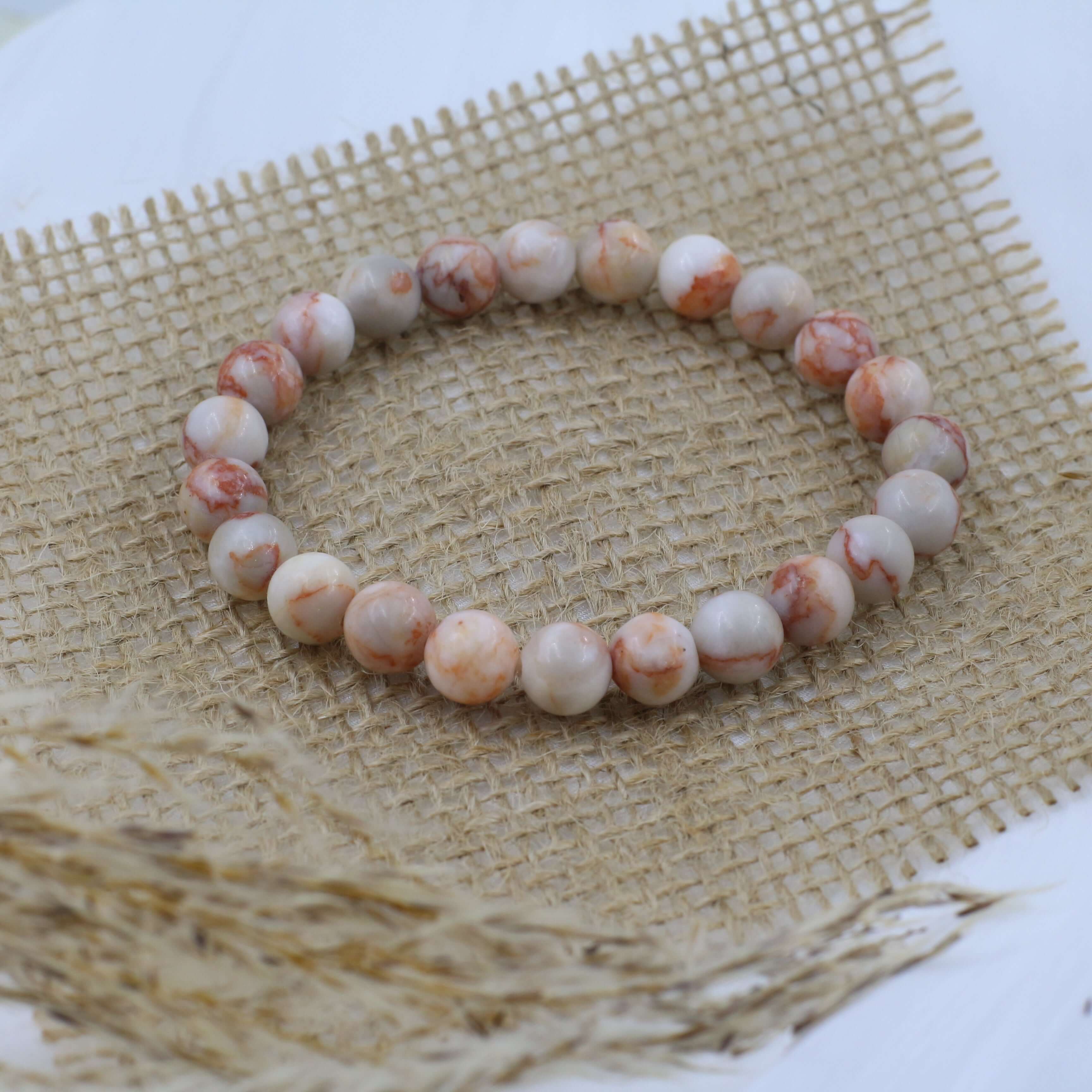 Elegant Red Grid Bracelet showcasing vitality on woven fabric background.