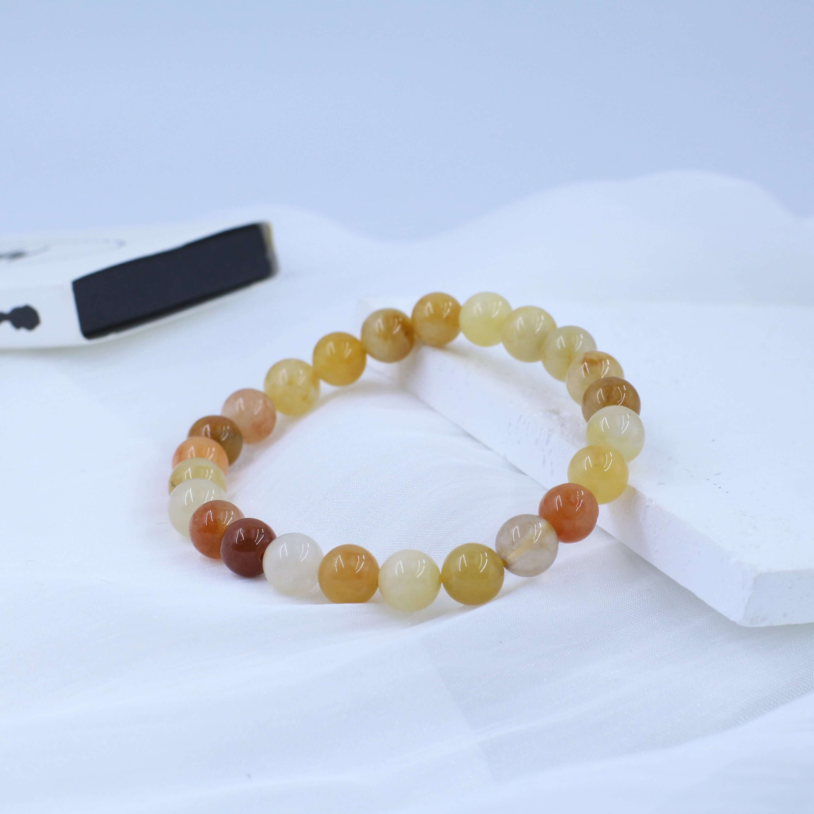 Noble Gold Silk Jade Bracelet for Wealth with high-quality golden beads displayed on a white surface.