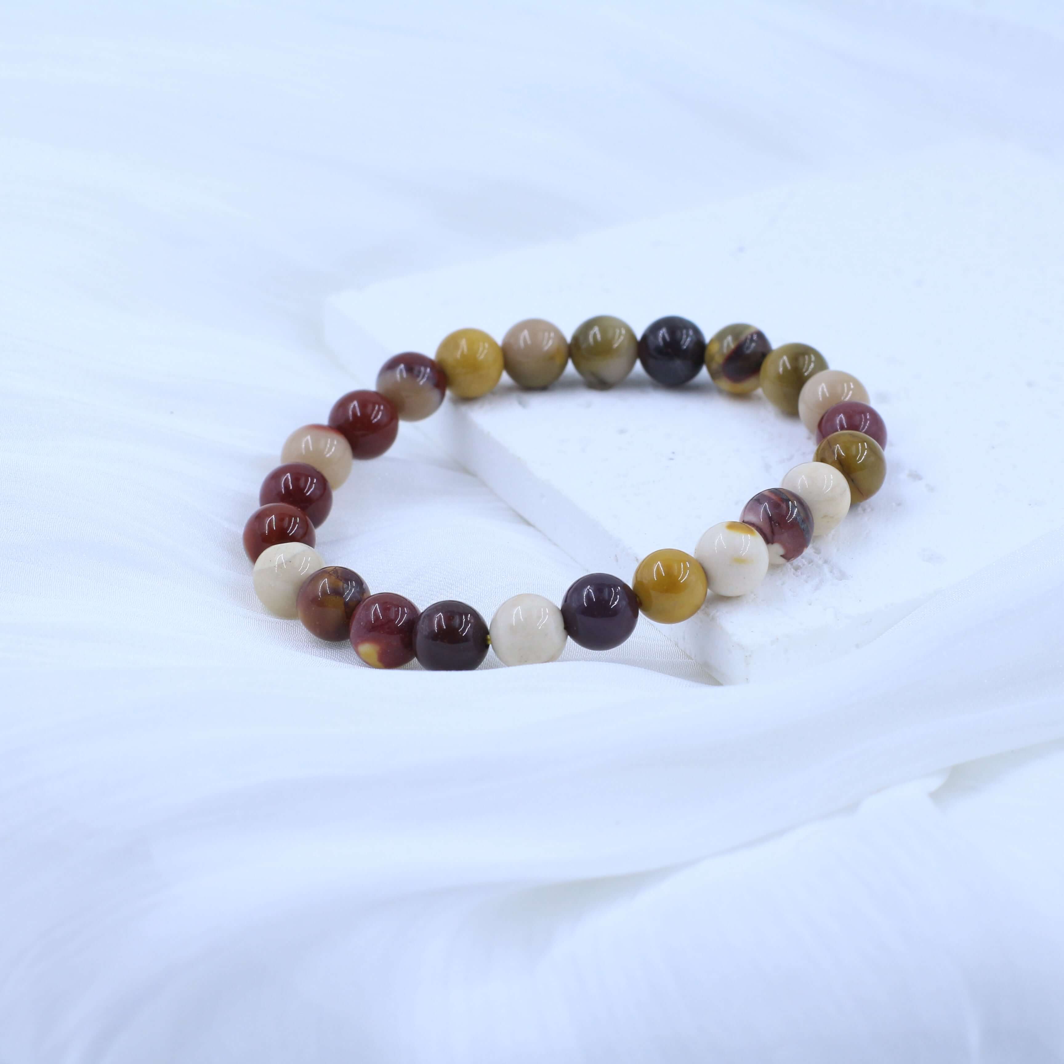 Warm Mookaite Bracelet for Confidence on white background with multicolored beads, enhancing vitality and self-belief.